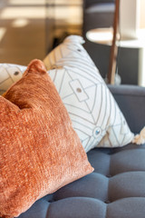 Modern white and orange pillows on couch