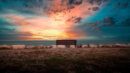 Sunset on the north wales coast UK bench looking out to sea