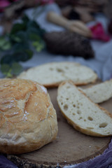 Artisan bread bun sliced on tablecloth in garden