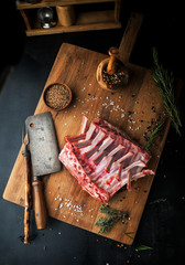 Raw rack of lamb with spices on a cutting board - 324365934