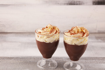 Hot chocolate cocoa in glas cup with whipped cream on vintage background