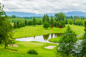 Golf course with gorgeous green and pond.