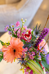 Fototapeta na wymiar Bunch of colorful flowers in vase on marble table