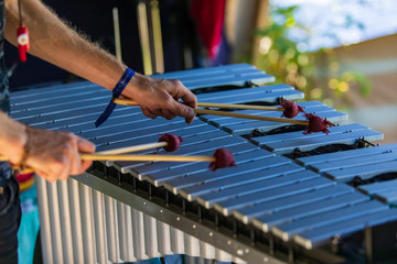 A close up soft focus shot on the hands of a man using four mallets to play a vibraphone instrument...