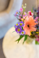 Bunch of colorful flowers in vase on marble table