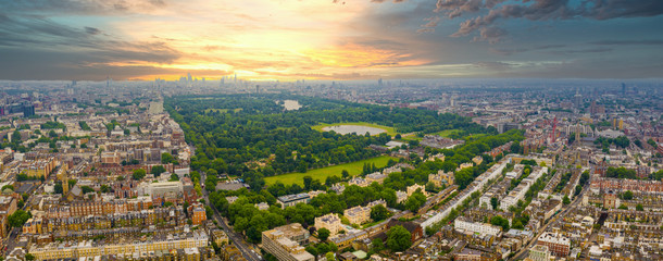 Beautiful aerial view of the Hyde park in London, UK. Magical sunset view over the park with London skyline on the horizon.