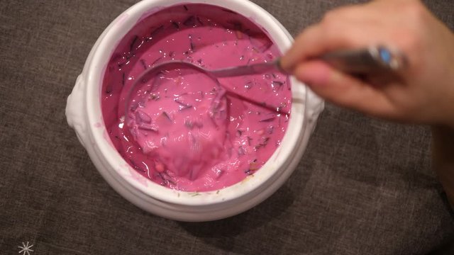 Beetroot cold Soup stirring in Bowl with Spoon. Ready to eat. Isolated close-up.