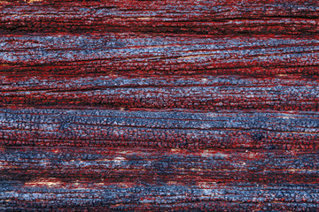 Relief background - a wall of charred logs with a red coating