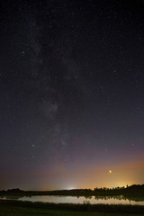 Fototapeta na wymiar Milky Way stars in the sky above the river. Night landscape photographed with a long exposure.