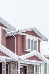 The top of a typical american home in winter. Snow covered roof and nice window.