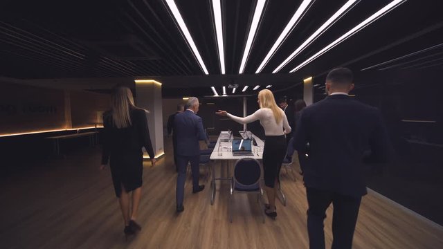 The group of business people entering the room