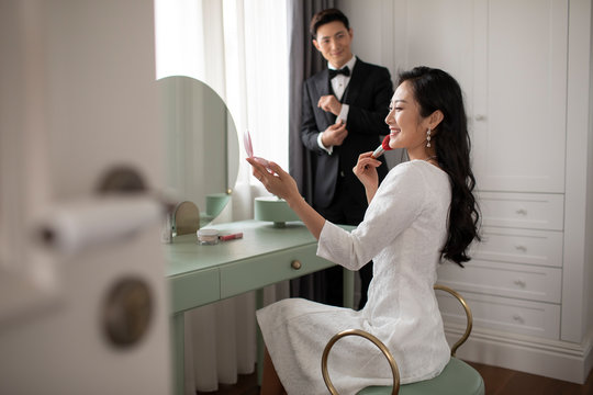 Young Chinese couple getting dressed at home