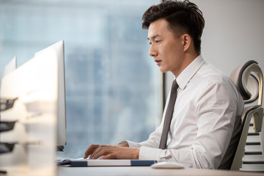 Young Chinese businessman working in office
