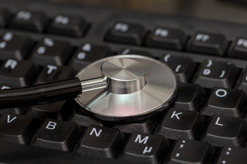 Close-up of stethoscope on computer keyboard