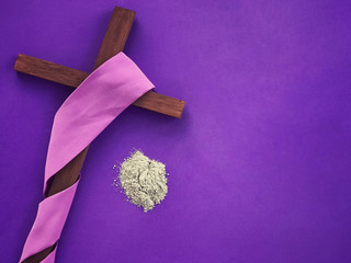 Good Friday, Lent Season, Ash Wednesday and Holy Week concept. Christian cross and ashes on purple background.