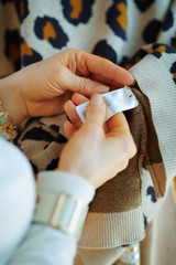 Closeup on woman checking label on sweater