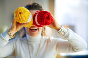 Closeup on cheerful female fool around with yellow and red yarn