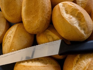 Top and close up view of German small plain breads roll, Brötchen, and bread knife.