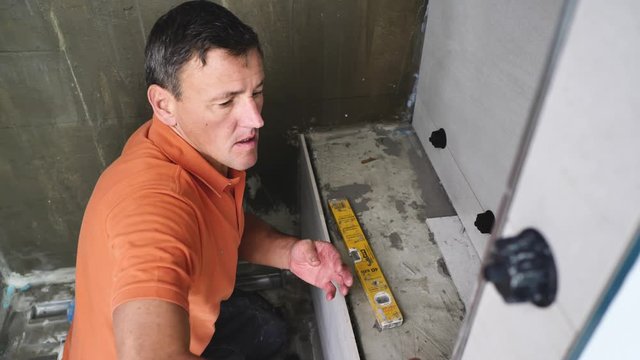  Fliesenleger bei der Arbeit, Renovierung eines Badezimmers 4k Video in zeitlupe