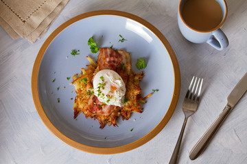 Potato cake with  bacon and poached egg, garnished with spring onion and parsley. Vegetable fritters, pancakes. Flat lay image
