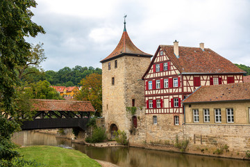 Wooden covered bridge and old tower in the historic center of Schw bisch Hall on the Kocher river, Baden-Wurttemberg, Germany.