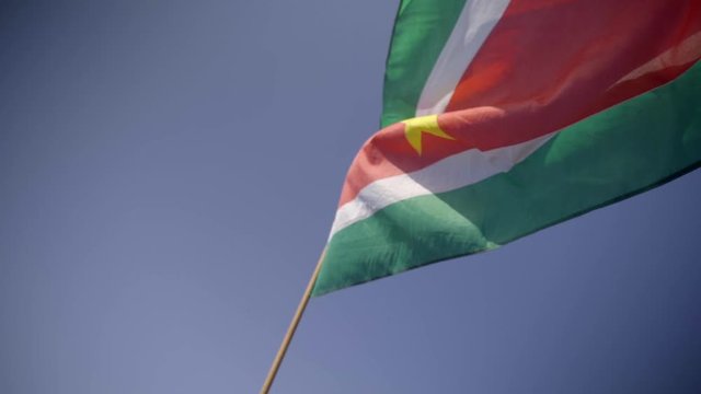 Flag of Suriname held up in the wind, slow motion