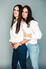 two sisters twins girl posing, making photo selfie, dressed same white shirt, diverse hairstyle friends, lifestyle people concept