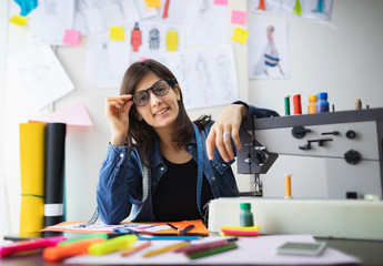 Portrait of young fashion designer with sewing machine