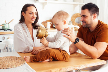 young family with little cute son on kitchen in morning happy smiling, lifestyle people concept