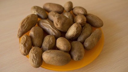 Fototapeta na wymiar Many baked potatoes in a peel on an orange plate. Healthy food on the table.