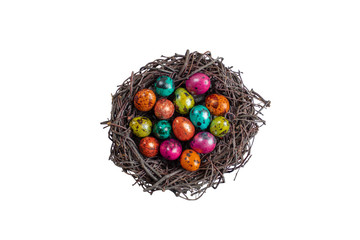 Painted quail eggs for Easter in a nest of branches. Isolated on a white background, different colors