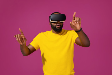 Naklejka premium Man touching air during the VR experience on purple background