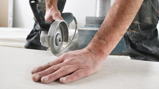 Fliesenleger schneidet fliesen mit einem winkelschleifer (flex) 4k video in zeilupe