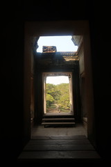 old passage in ancient angkor wat temple ruins leading to green forest, jungle in cambodia, path to nature, cambodia