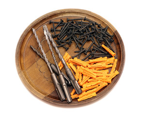 Erection tools. A drive screws, drills and dowels on a wooden tray isolated.