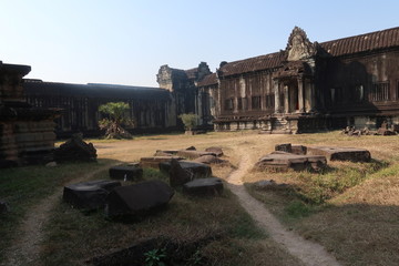 beautiful inner courtyard of ancient angkor wat temple ruins, stone, rocks, gras and palms, sunny day