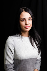 Portrait of serious beautiful female with black hair, has minimal makeup, looks calmly at camera,...