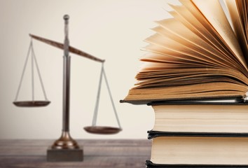 Law scales and books on wooden table. Symbol of justice