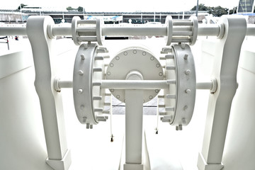 Complex mechanical machine with cogwheels, transmission, bearings and shafts, painted white.