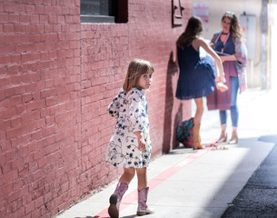 Young child walking in a dress and boots at a photo shoot