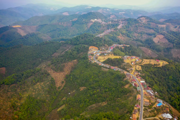 Fototapeta na wymiar aerial scenic view of mountain road and rural village living along, in Laos. 