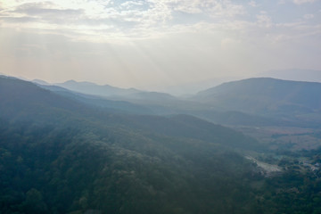 High angle scenic view of mountain against foggy sky 