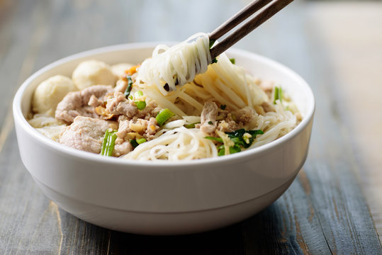 Rice noodles soup with pork and meat ball in a bowl eating by chopsticks, Asian food