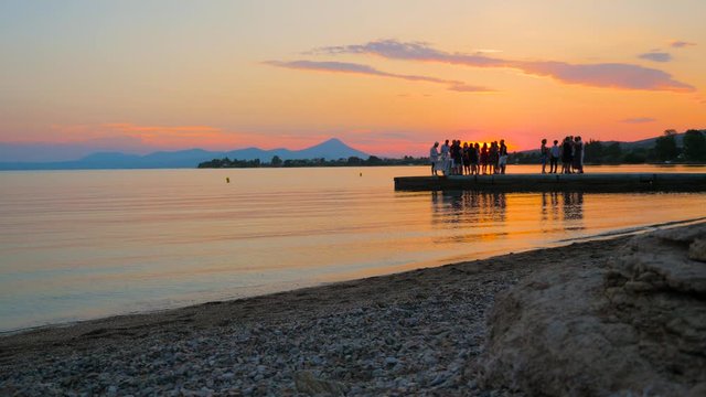 Background party on the beach. Outing team background. TeamYouth party near the sea. Party on seaside during sunset. Group of young people on the beach in sunset. Summer vacation background