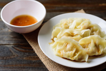 Steamed wonton dumpling stuffed with minced pork and shrimp eating with sesame oil sauce