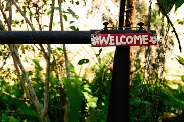 Rustic red wood welcome sign hanging on steel frame