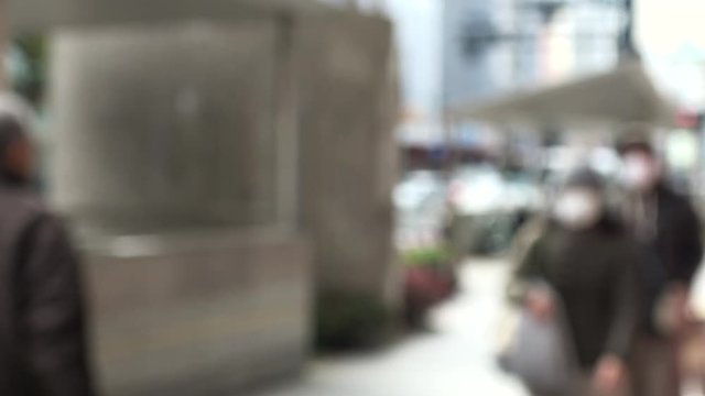 マスク姿で歩く人々 ぼかし背景 4K / Blurred shot of people with mask walking on the street. 4K