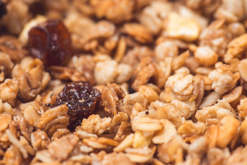 Useful and tasty muesli with nuts, rasins and flakes. Selective focus macro shot with very shallow depth of field. Healthy and vegetarian lifestyle