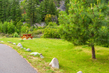 Picnic Table in Park with mountain lake background.