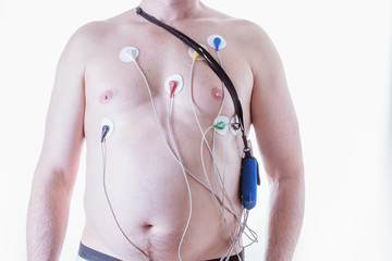 A man with a device for daily measurement of a cardiogram on a light background. The method of the...